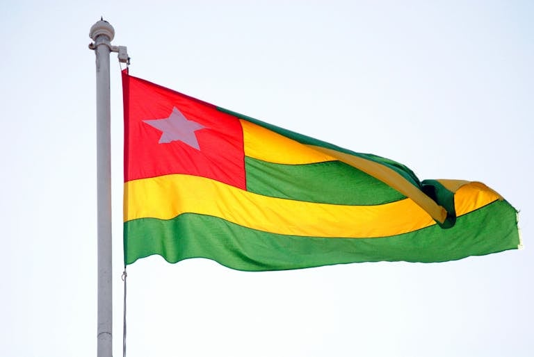 Vibrant Togo national flag waving proudly on a sunny day in Lomé.